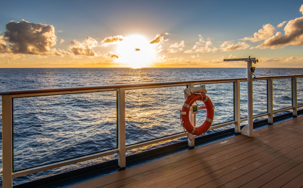 Sunset on cruise vacation. Sun just above the horizon and promen