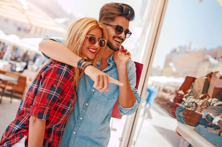 Beautiful young couple enjoying in shopping, having fun together. Consumerism, love, dating, lifestyle concept