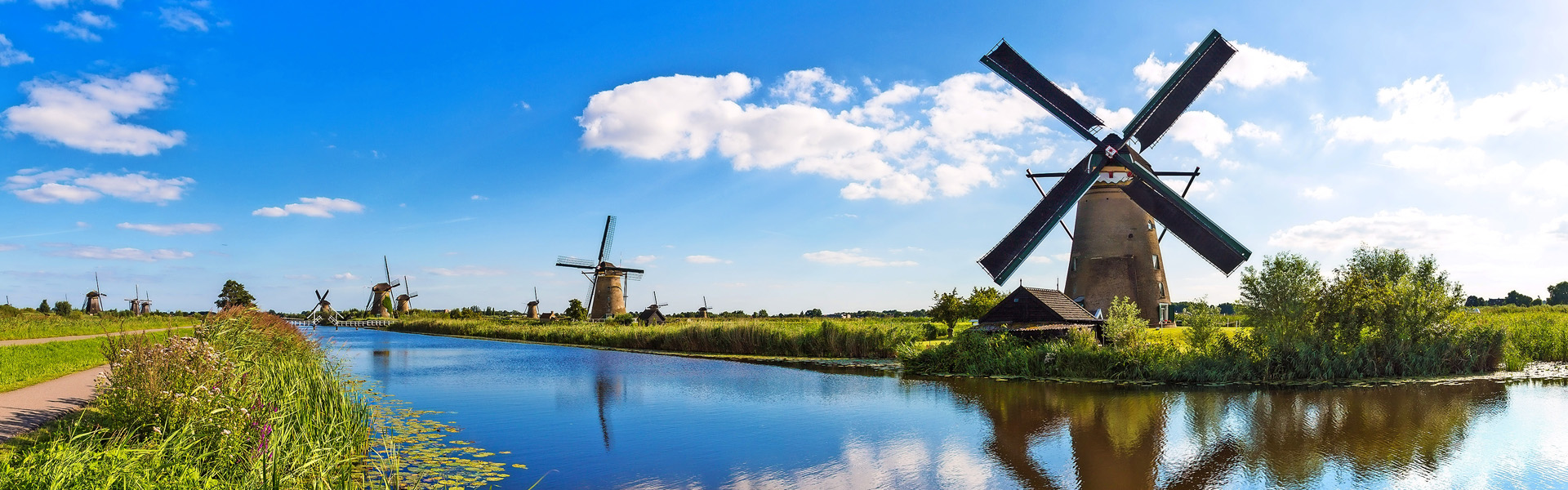 Windmills and water canal in Kinderdijk in a 

beautiful summer day, Holland