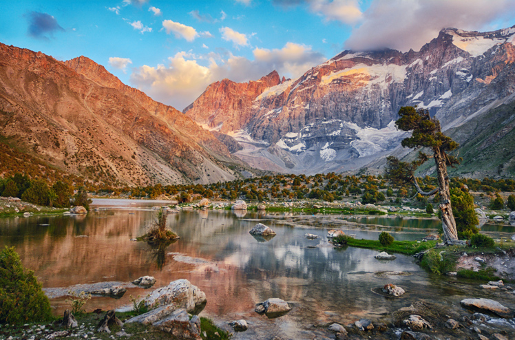 Landscape of beautiful Fan mountains and Kulikalon lake in Tajikistan on blue cloudy sky background